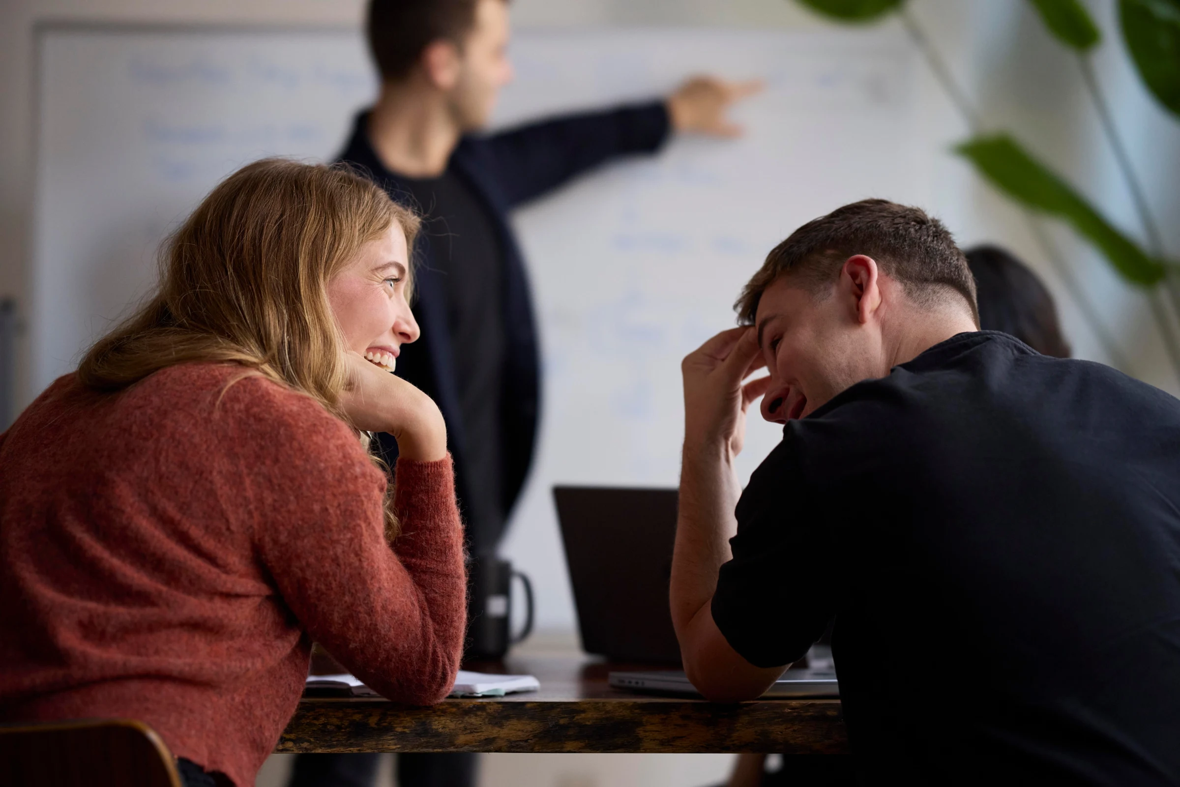 Two colleagues laughing together at work