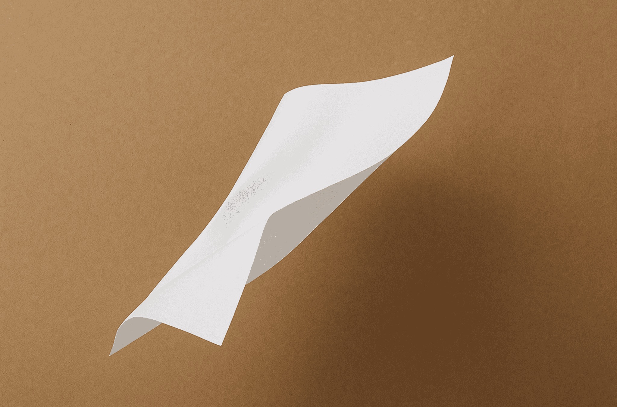 A single sheet of paper resting on a warm brown surface